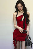 Woman wearing a red dress with black accents against a plain background