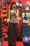 Woman taking a mirror selfie in a store with colorful displays and 'Tom & Cloth' branding.