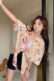 Woman wearing a colorful floral kimono-style shirt indoors.