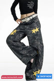 Black camouflage pants with yellow stars worn by a person on a white background