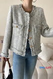 Person wearing a textured gray jacket with wooden buttons in a casual setting.