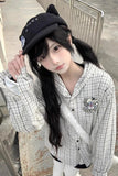 Person wearing a black cap and checkered shirt with a graphic design.