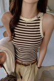 Woman wearing a striped tank top in an indoor setting