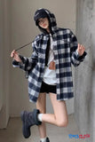 Person wearing a plaid shirt and black cap in an indoor setting