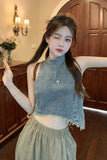 Woman wearing a denim top and light green pants in an indoor setting