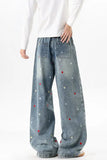 Person wearing blue jeans with star patterns on a white background