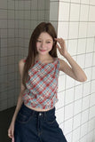 Woman wearing a plaid top and jeans standing in a tiled room.