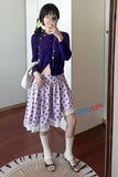 Person wearing a purple cardigan and polka dot skirt, holding a phone with 'JUNICLOTH' branding.