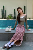 Woman sitting by a pool with cacti in the background