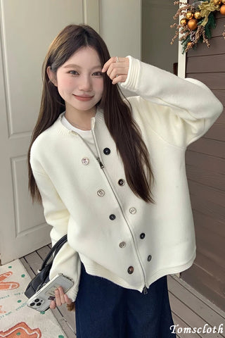 Woman wearing a white jacket with black buttons indoors