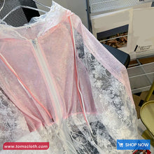 Lace fabric with floral patterns on a hanger, brand 'TomsCloth' visible