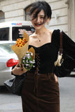 Woman holding flowers on a city street with 'Tomtoc' branding in the corner.