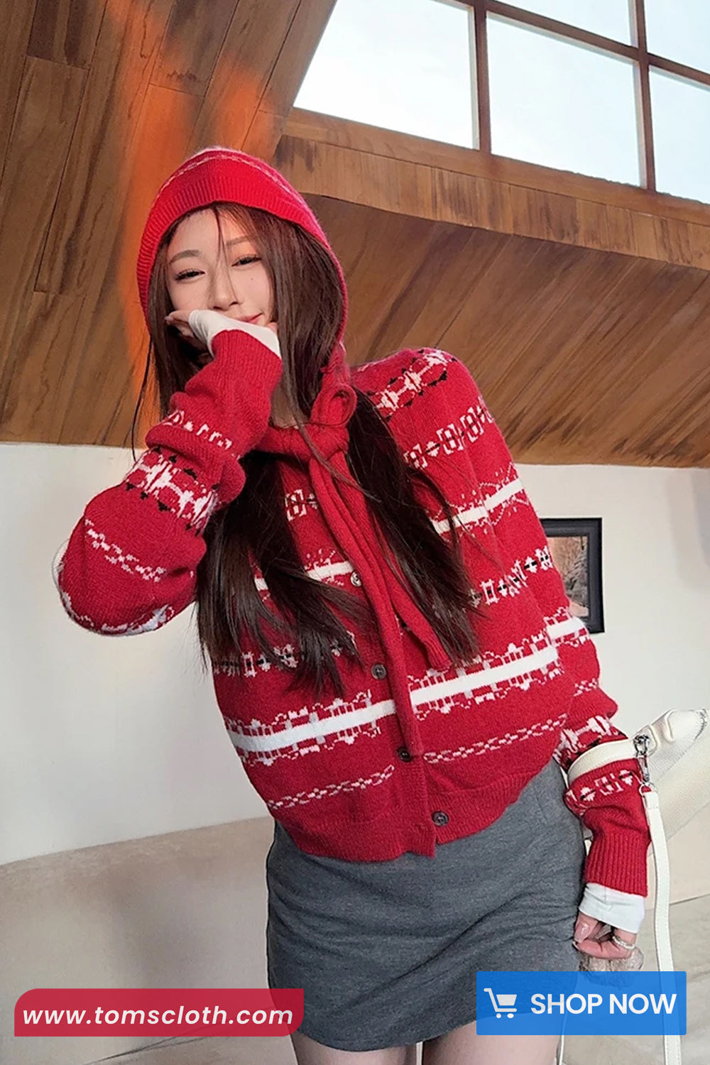 Person wearing a red patterned jacket indoors with a visible brand logo.
