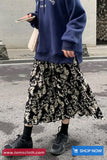 Person wearing a navy blue hoodie and patterned skirt on a street, with 'tomscloth.com' branding.