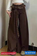 Brown wide-leg pants with a plaid belt worn by a person, with 'tomscloth.com' branding at the bottom.