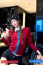 Woman in a red sweater and black hat sitting in a modern interior setting with 'Toms Cloth' branding.