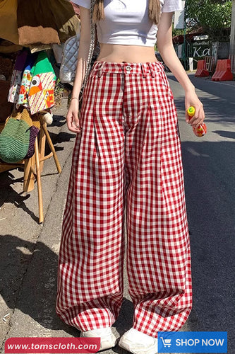 Person wearing red and white checkered pants on a street.