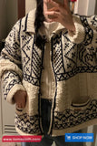 Person wearing a patterned cardigan with a visible brand logo at the bottom.