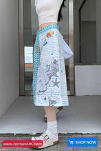 Person wearing a colorful skirt with animal prints in an indoor setting.