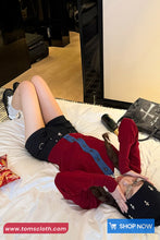 Person lying on a bed wearing a red dress and black shorts with a shopping cart icon and text overlay.