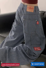 Blue striped pants with brand labels on a neutral background