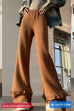 Brown ribbed pants worn by a person indoors with a visible brand logo.