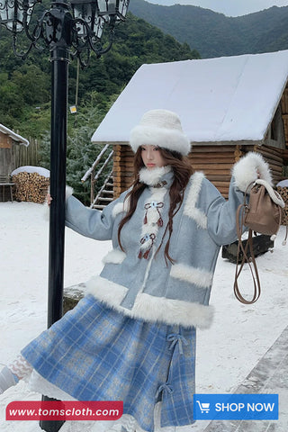Woman in winter clothing with a snowy background and wooden cabin.
