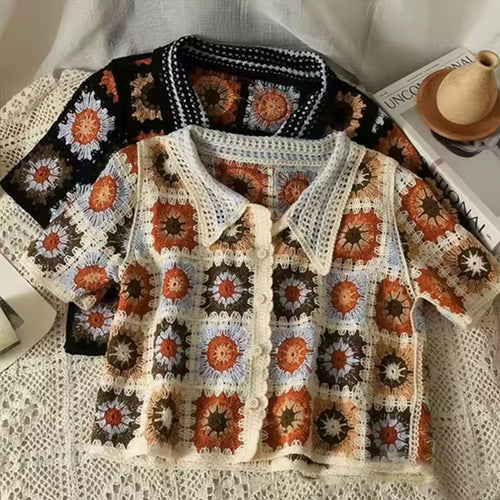 Colorful crochet cardigan with floral pattern on a textured surface
